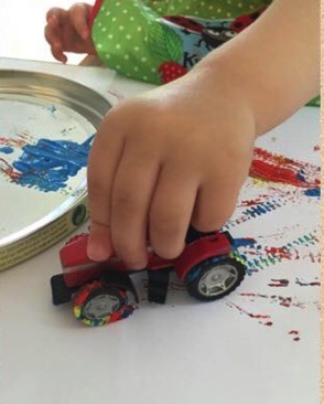 kid painting with a car