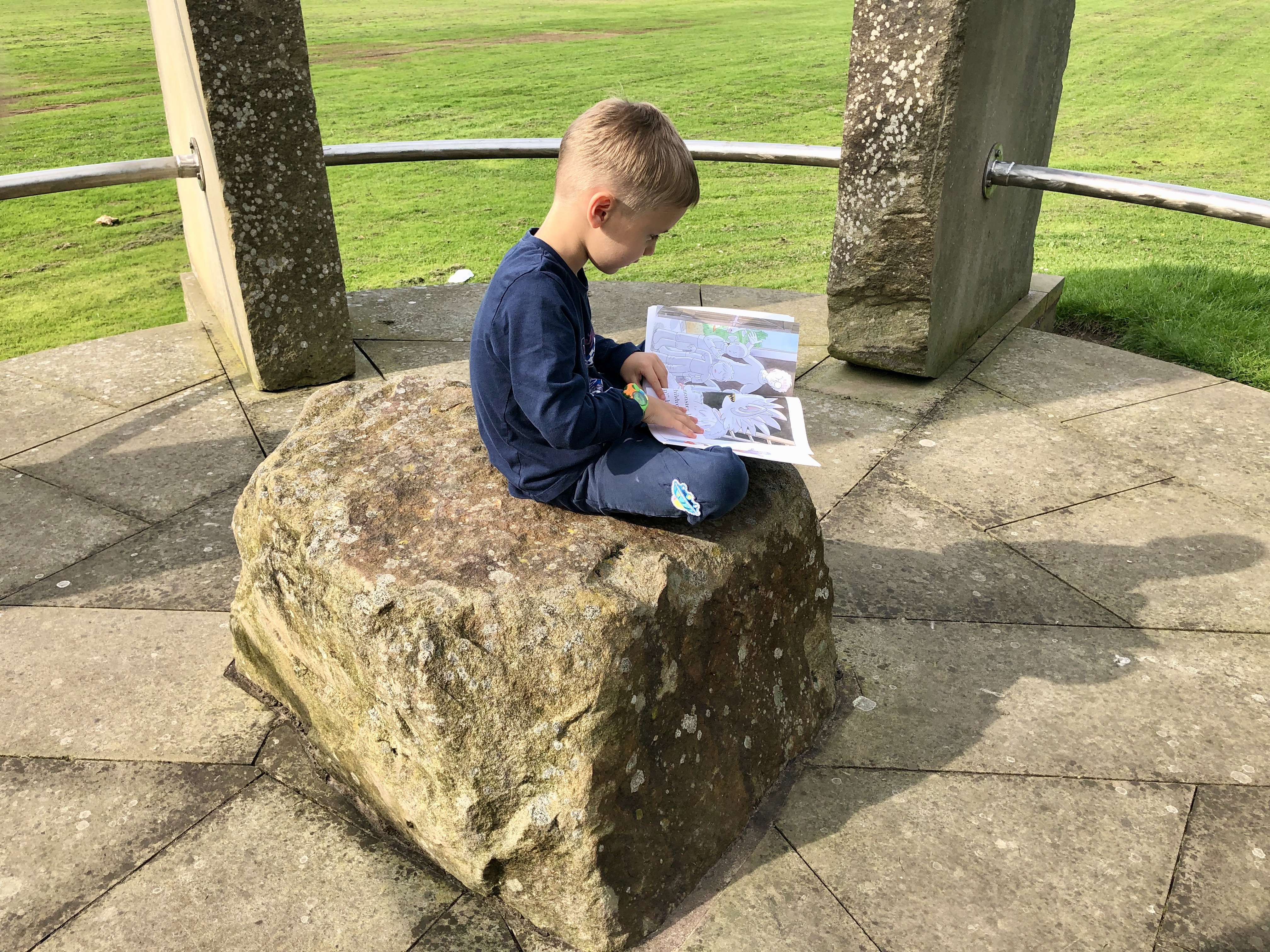 patrik reading a book on a rock
