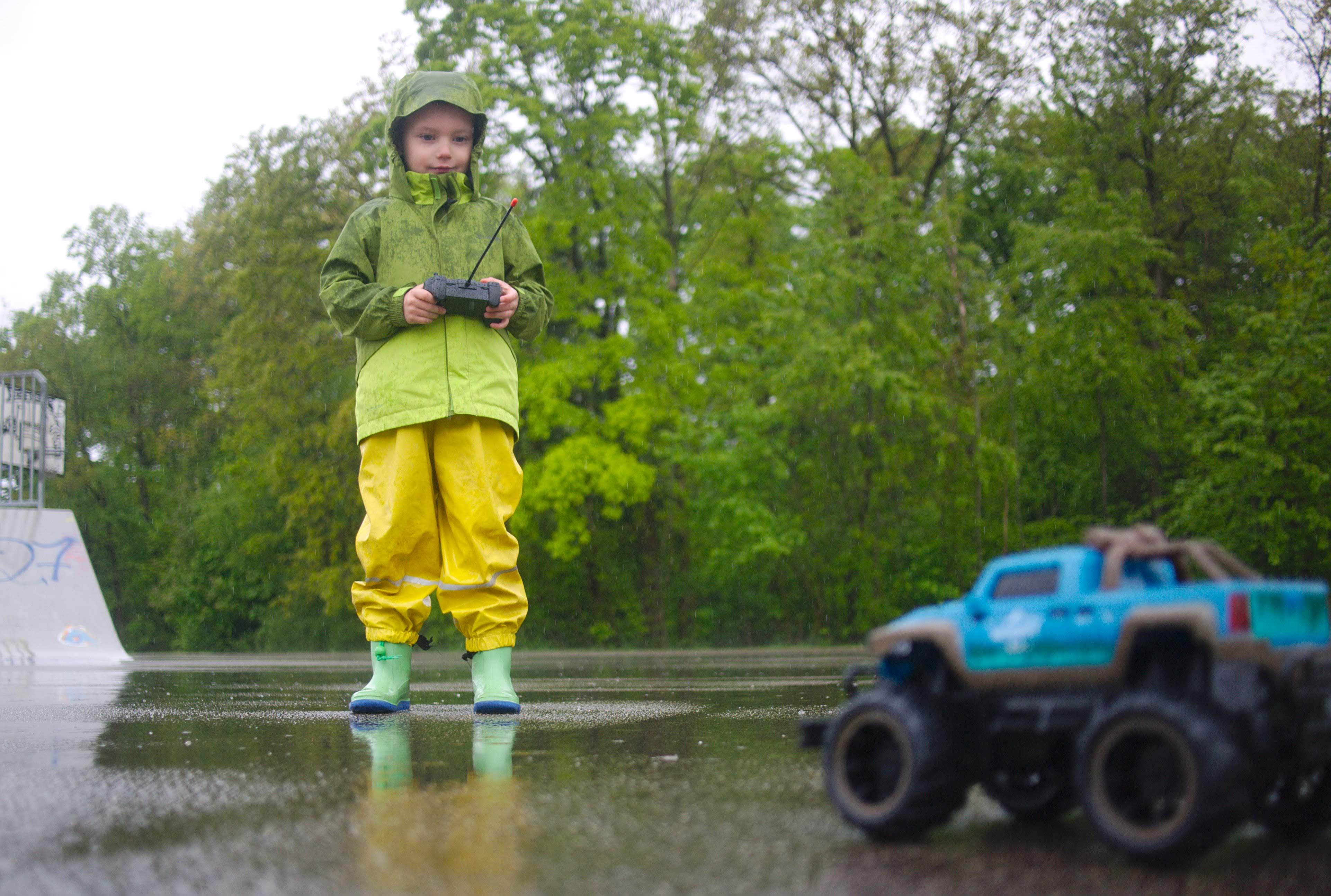 kid driving a remote car in rain