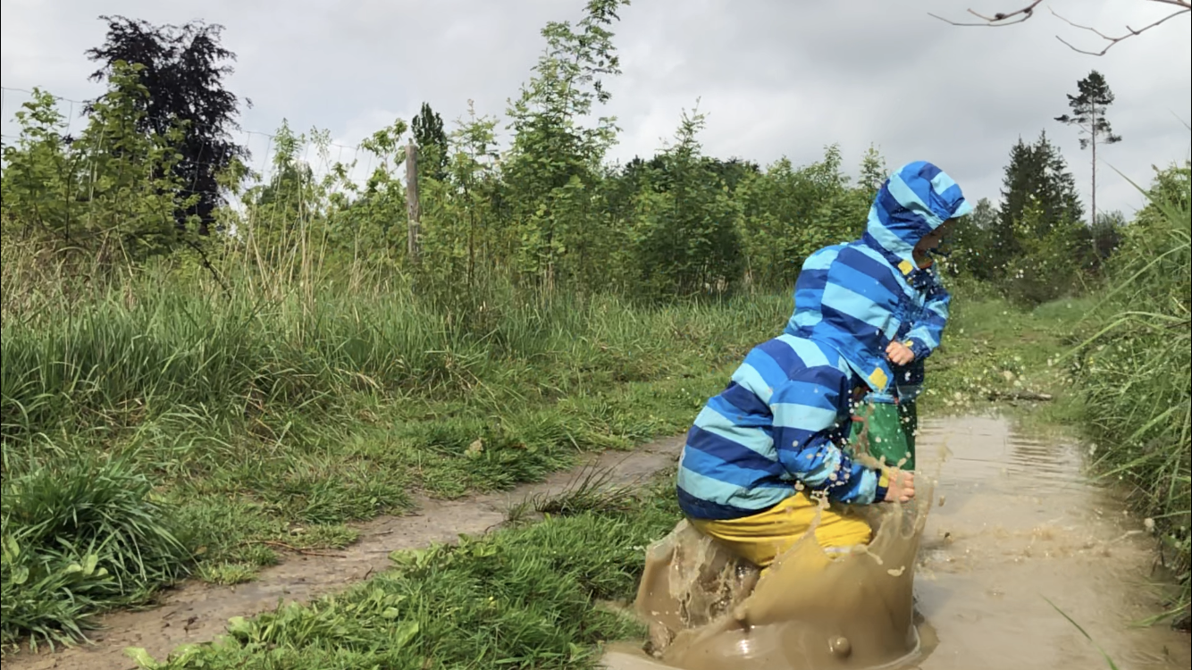 kid jumping in a puddle