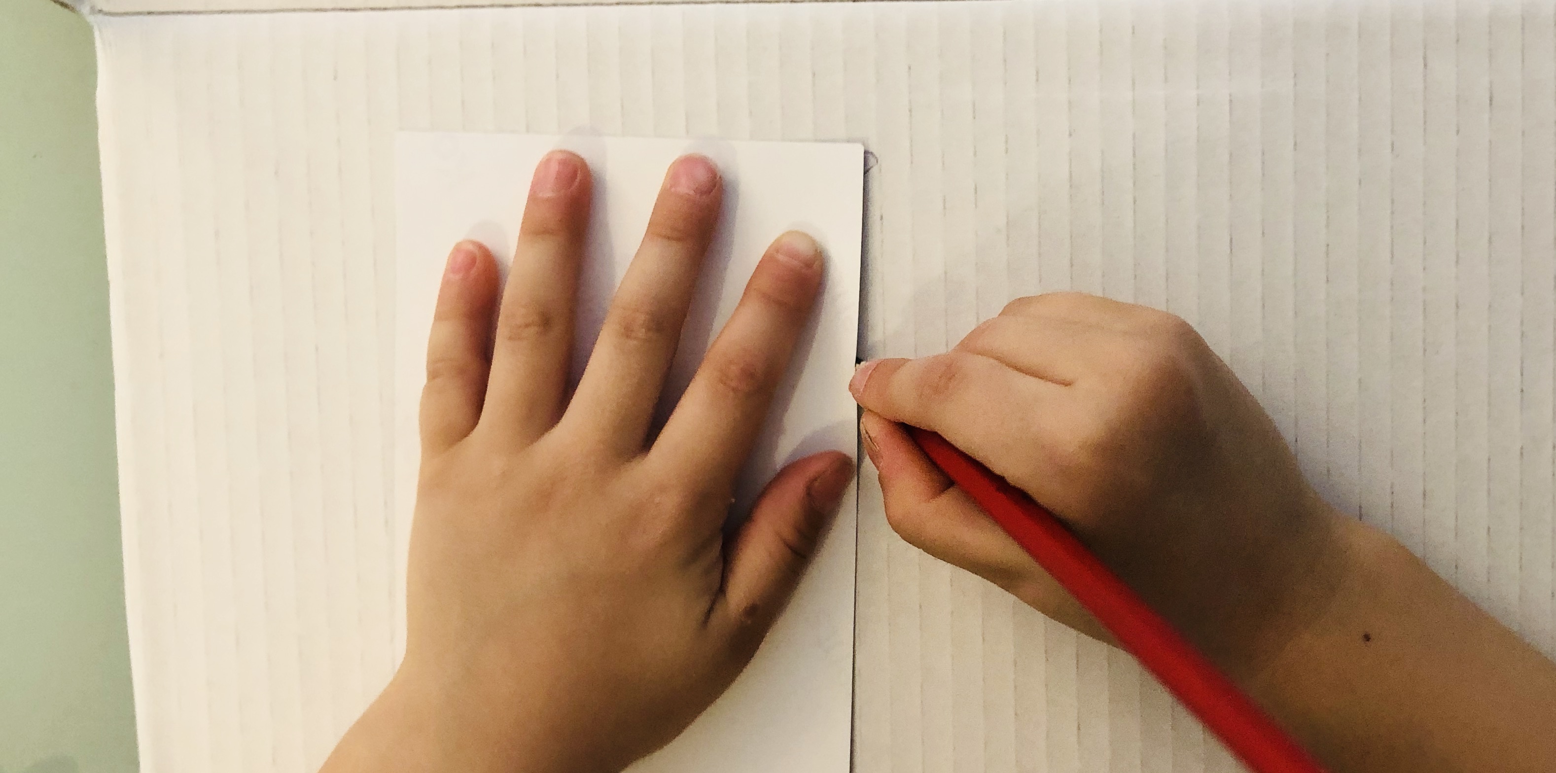 kid outlining a picture area on cardboard