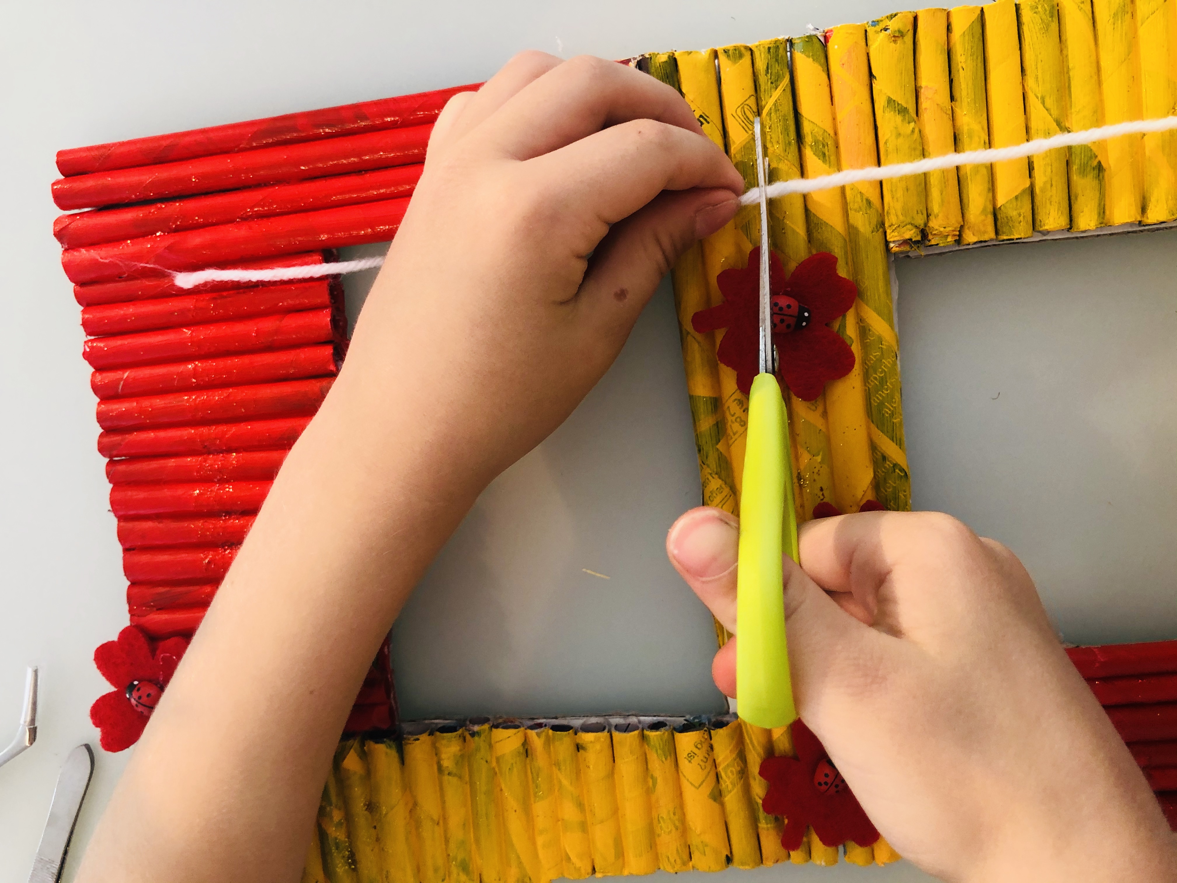 kid cutting a piece of wool string