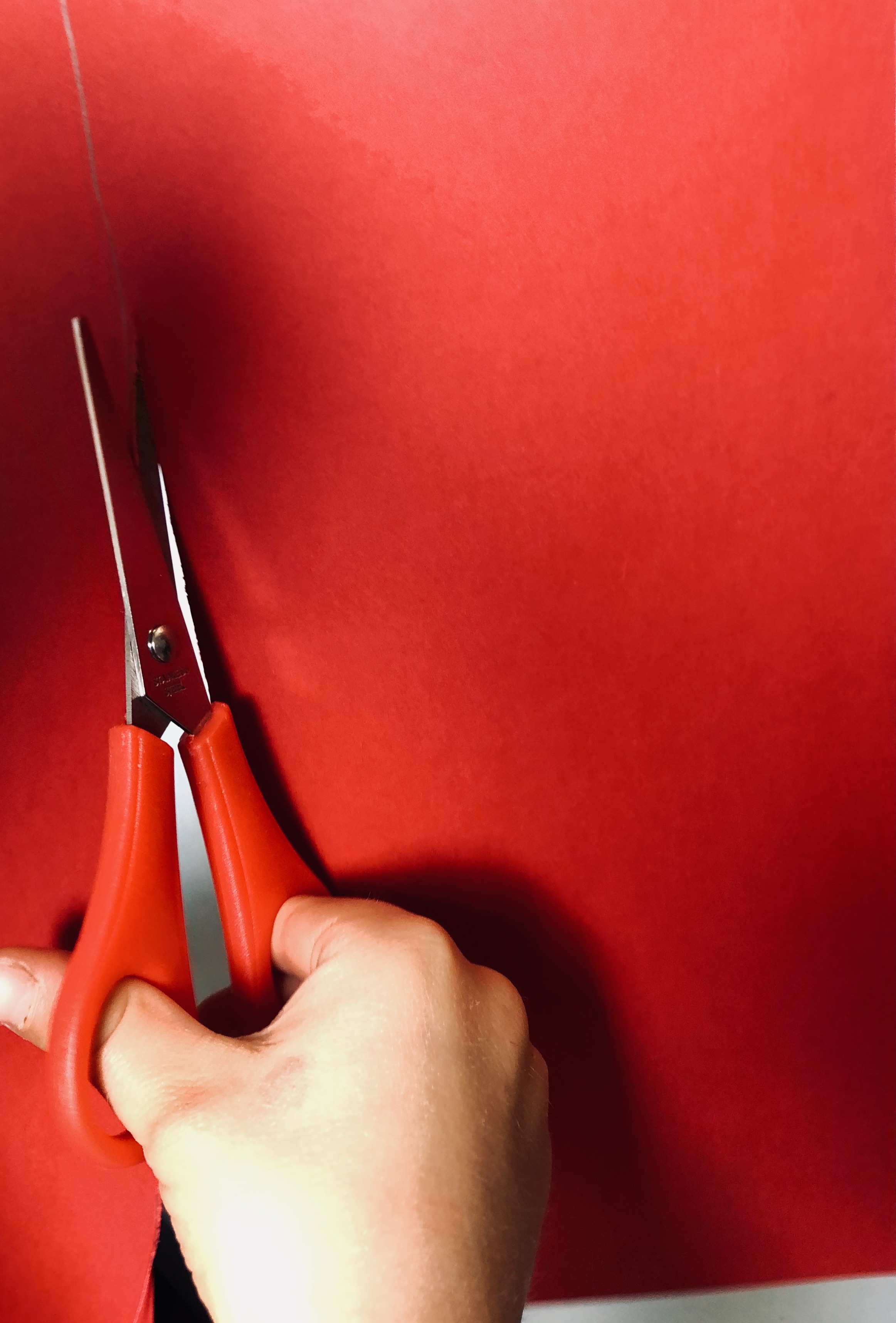 kid cutting red paper for an upcycling project city