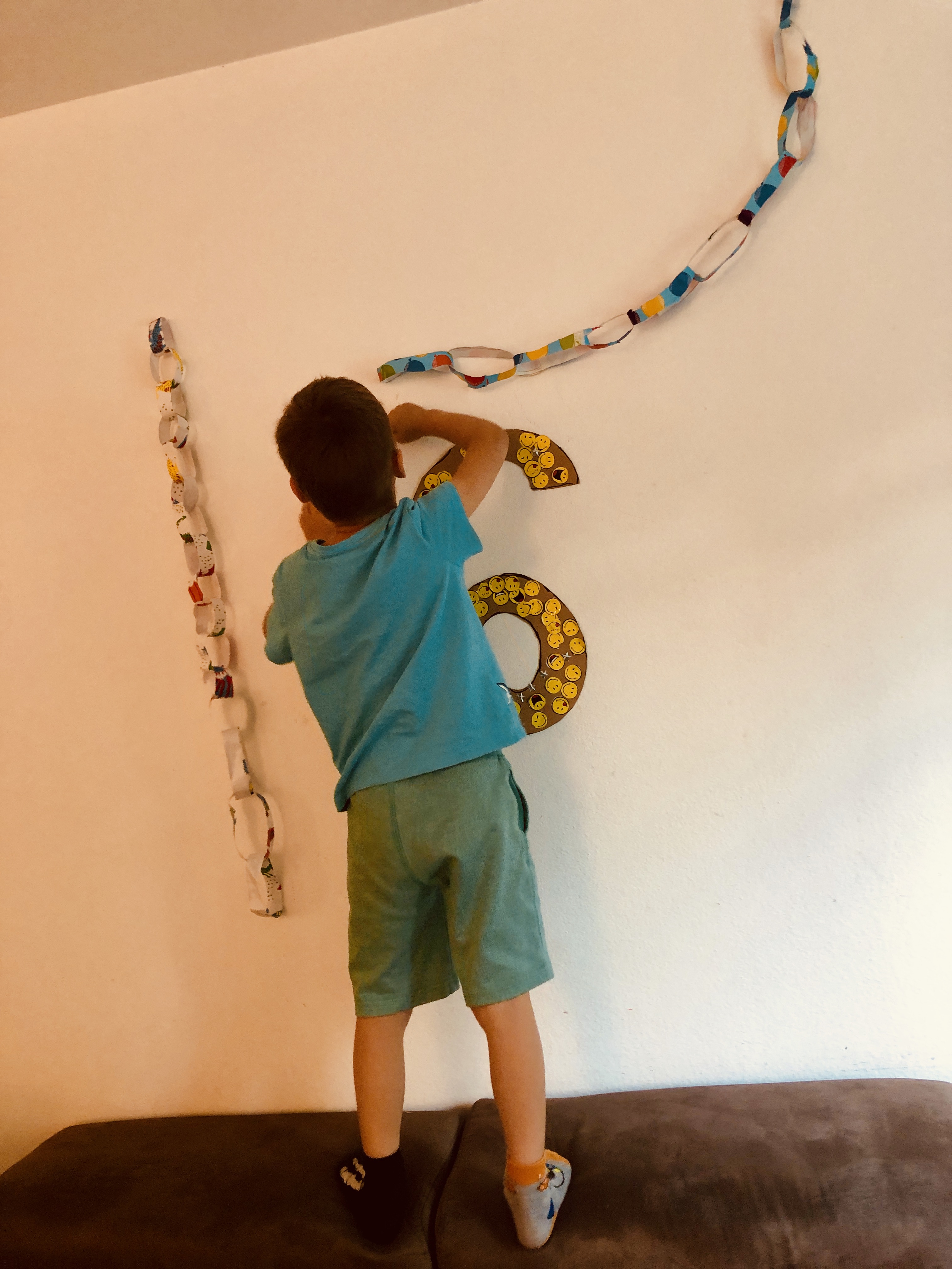 kid putting DIY decorations on the wall