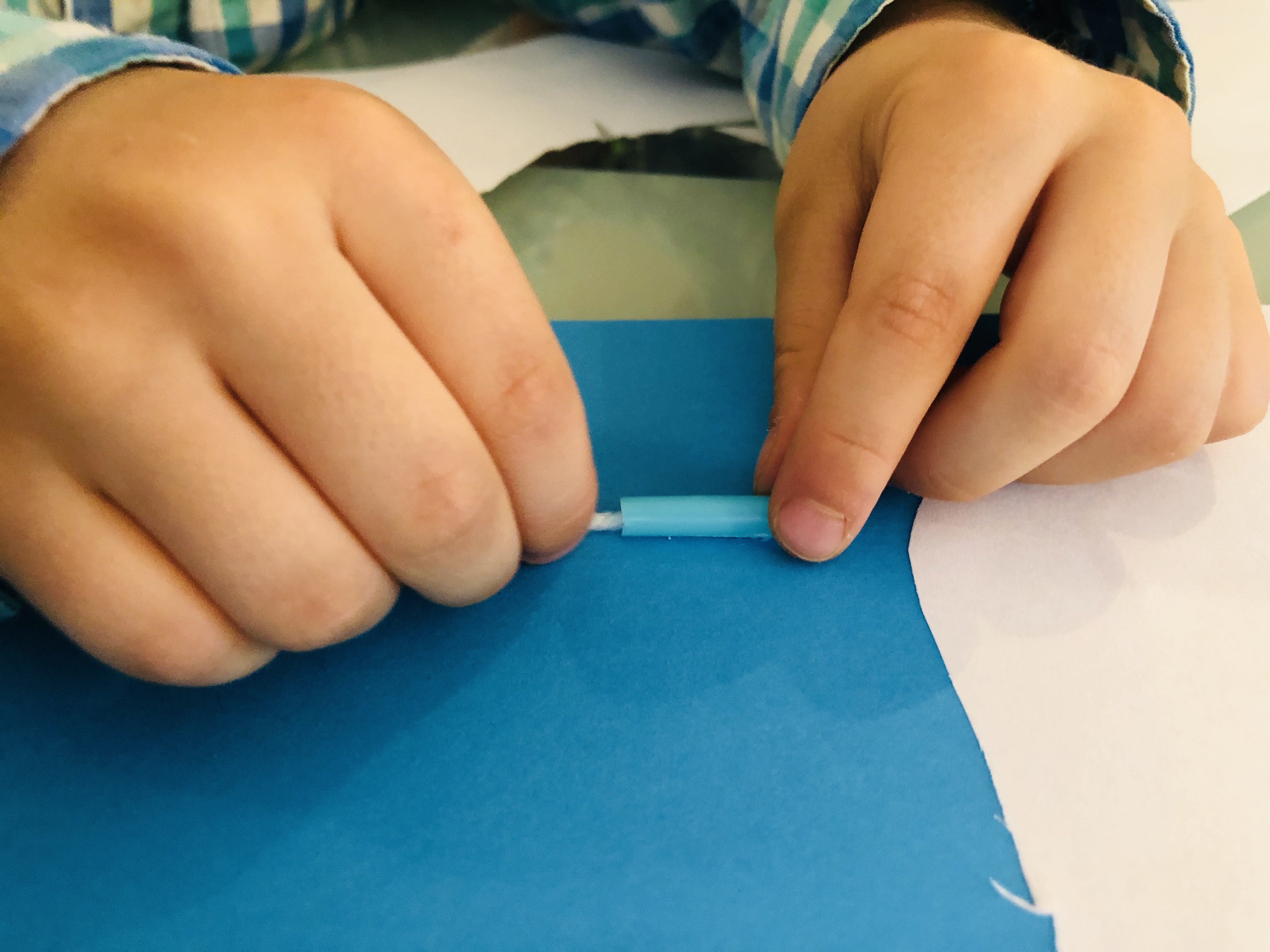 pulling the wool thread through the straws