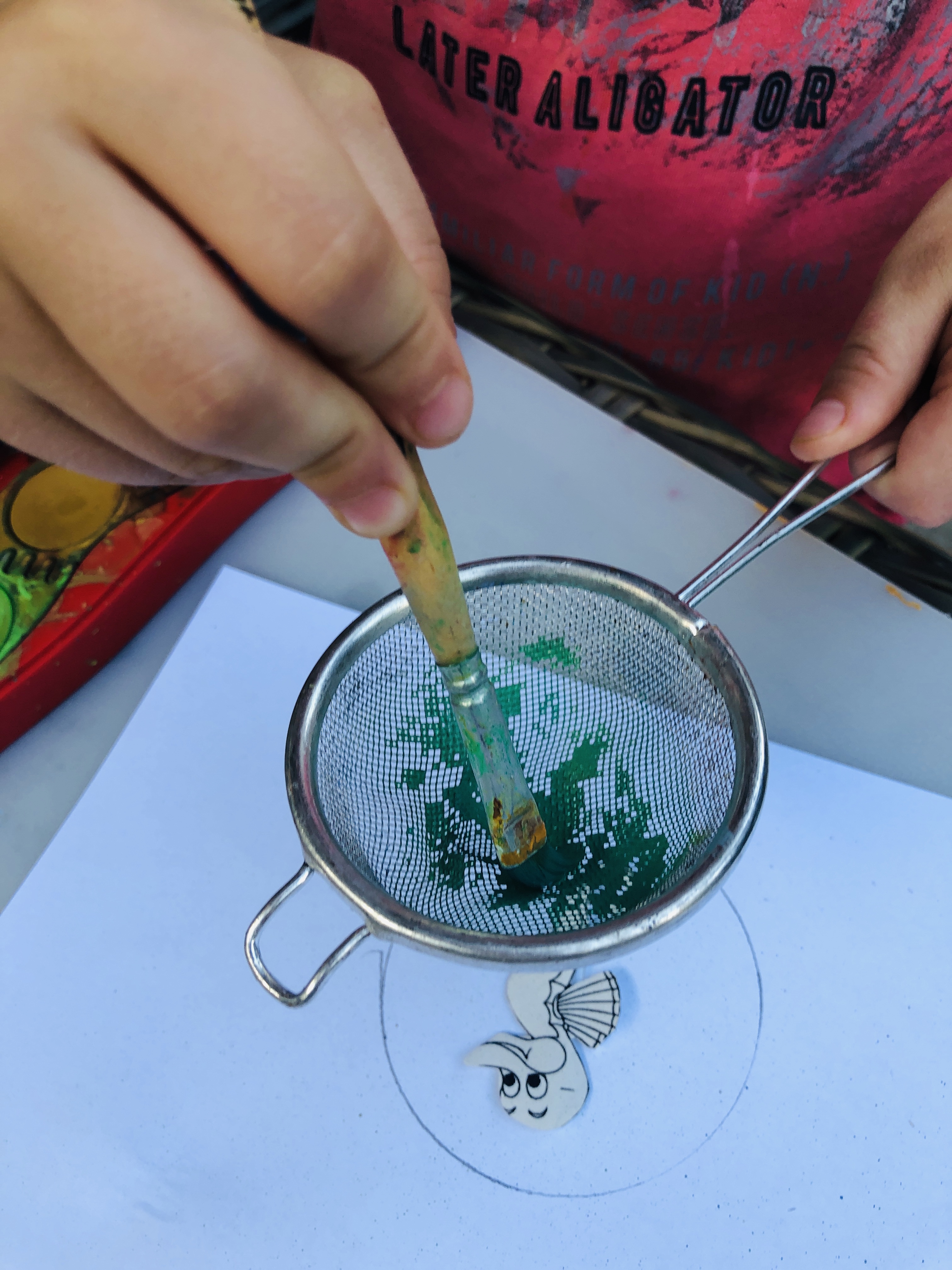 painting a seahorse using a hand colander