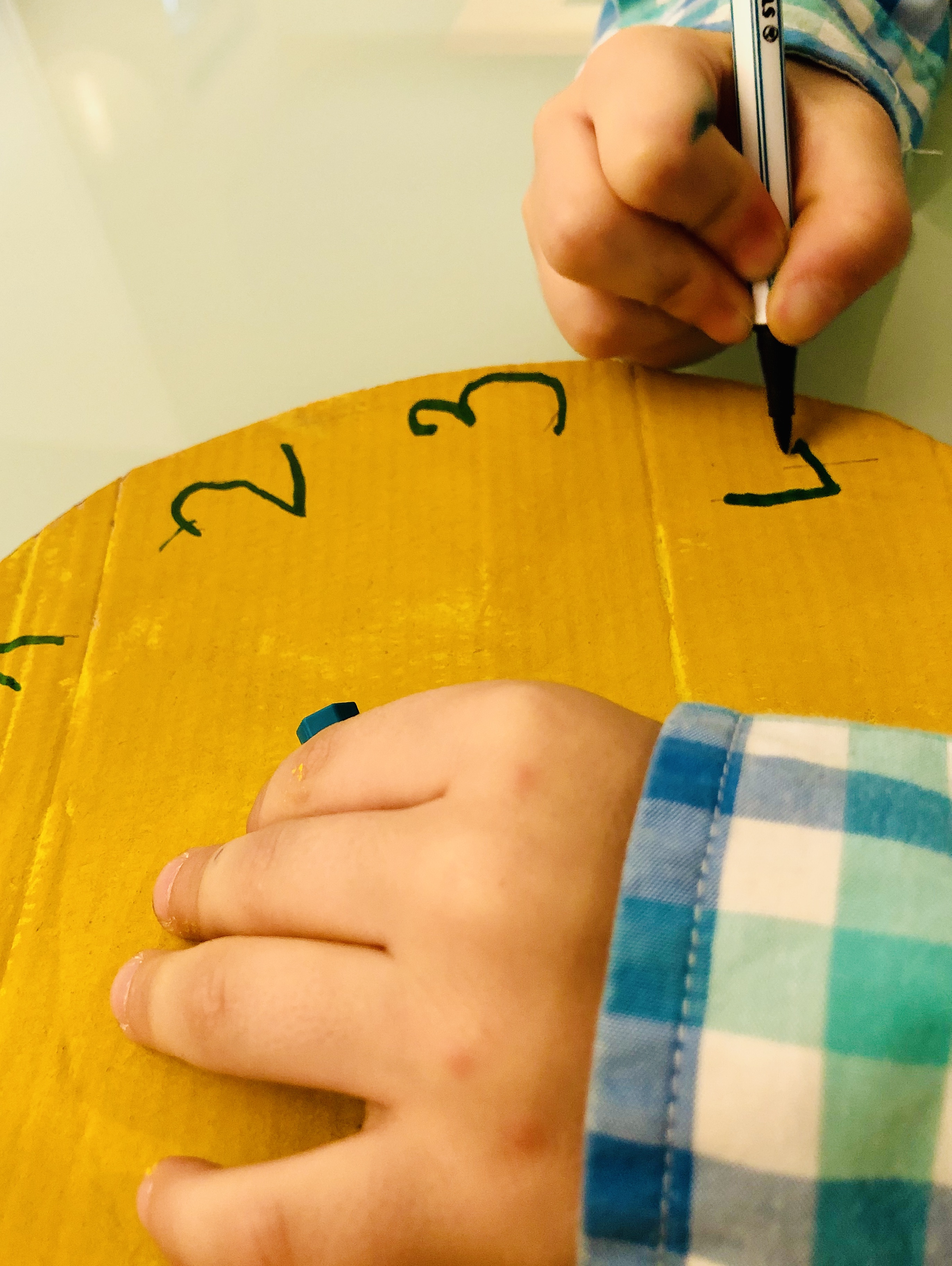 kid writing numbers on a clock