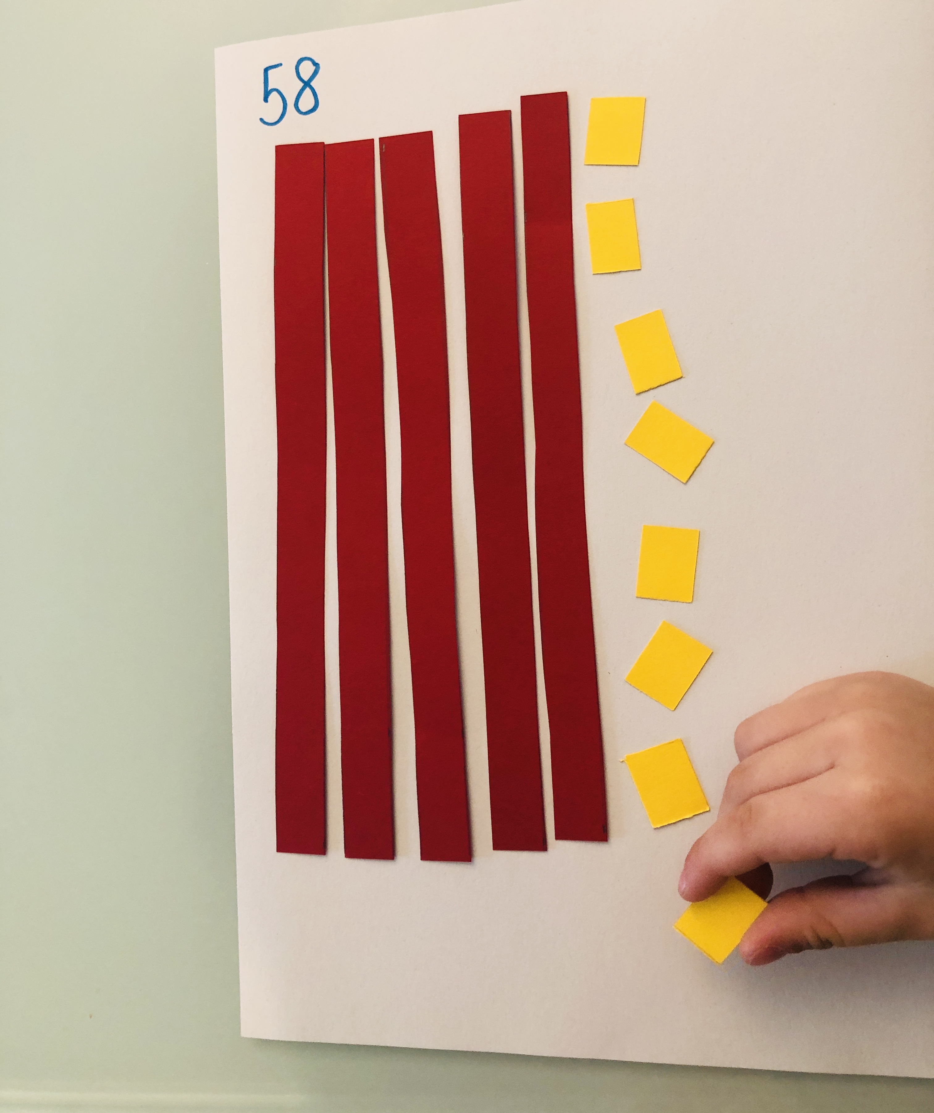 kid putting red and yellow cut-outs for numbers