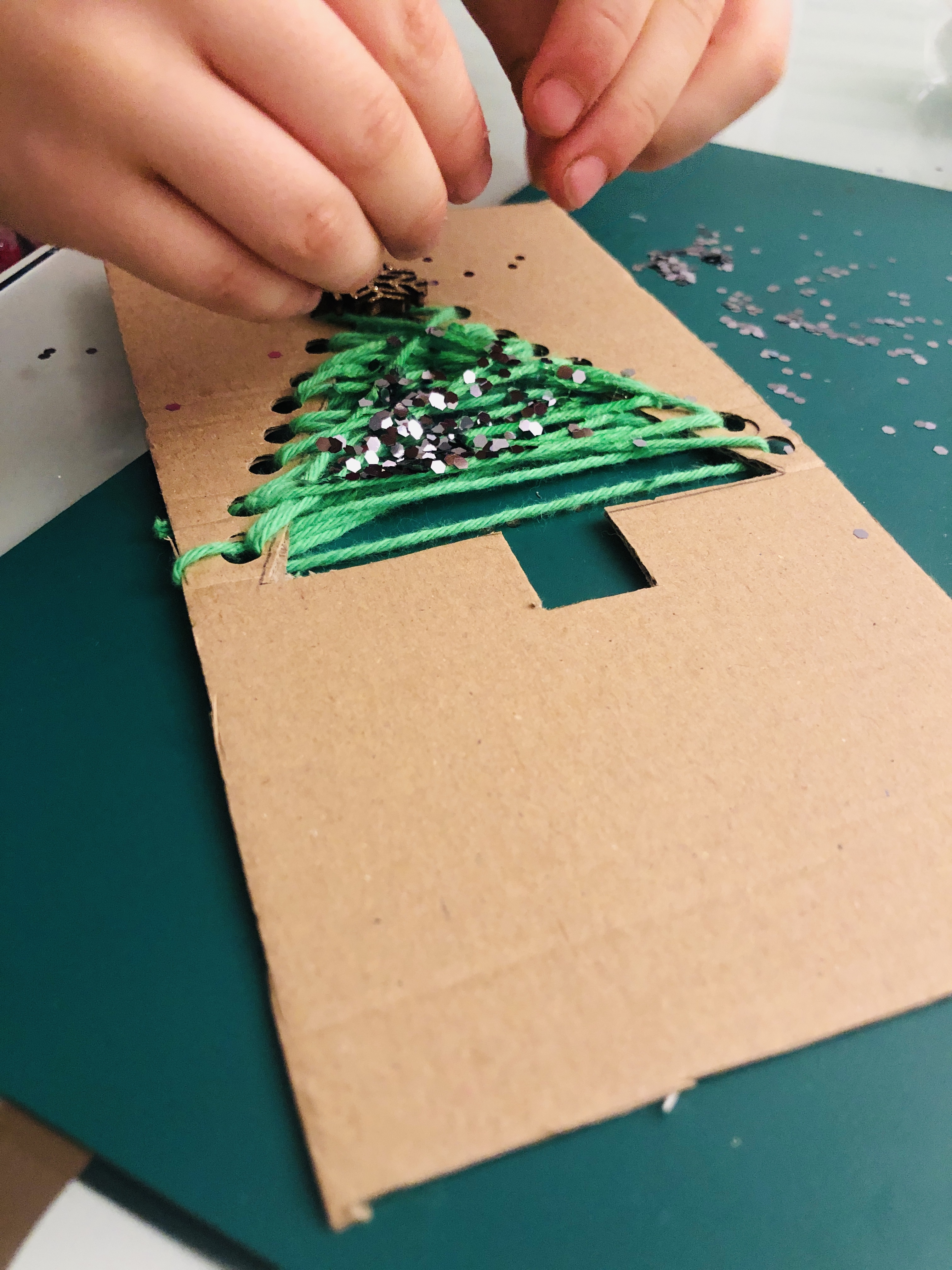 putting glitter on a cardboard tree